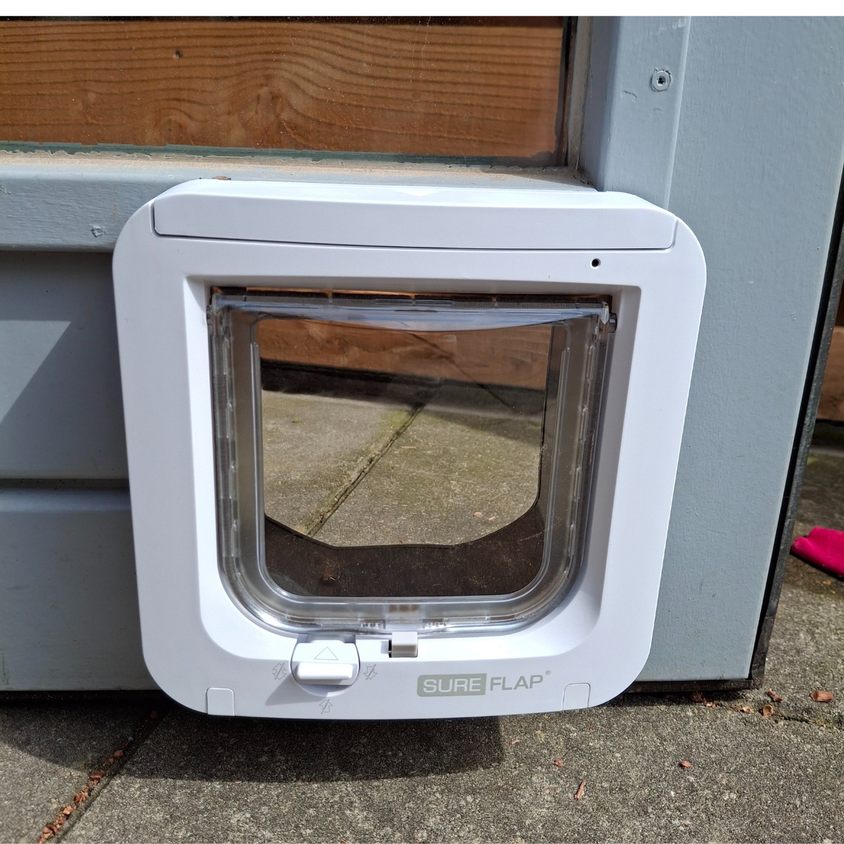 Wit kattenluik ingebouwd in een houten schuurdeur